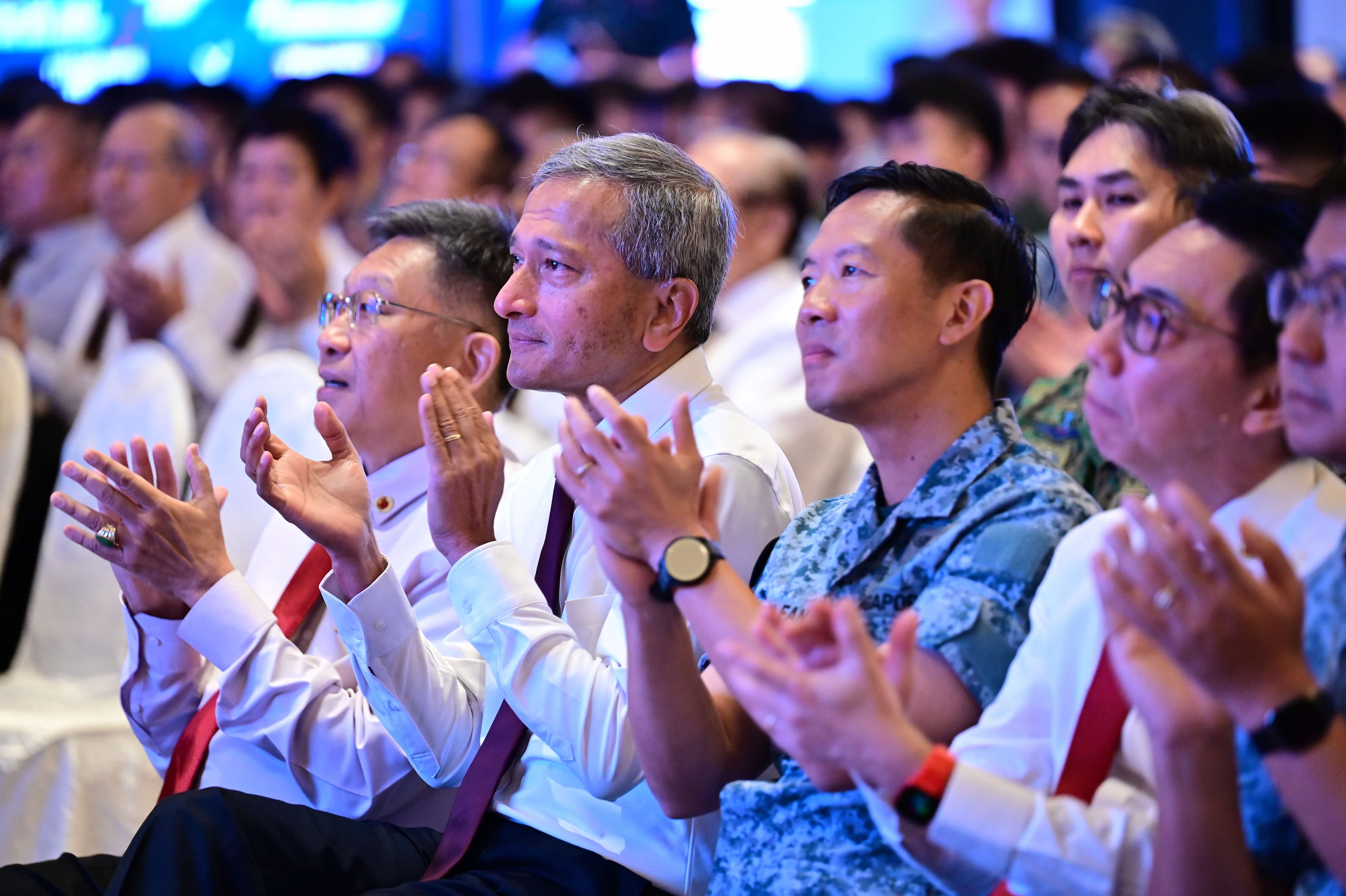 Crowd of people including PM Lee Hsien Loong clapping at event.